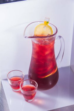 Beyaz arka planda bir bardak taze kırmızı limonata.