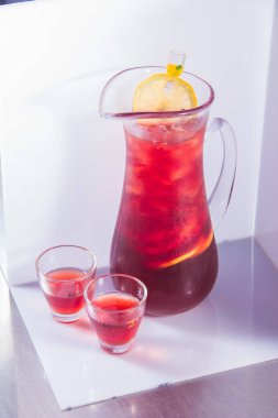 Beyaz arka planda bir bardak taze kırmızı limonata.