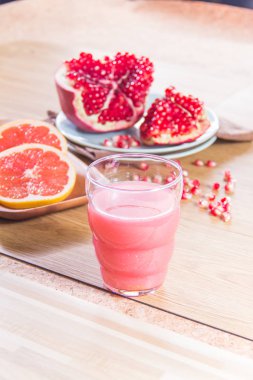 Nar ve ahşap zemin üzerinde greyfurt ile taze meyve suyu