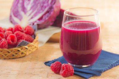 Taze ahududu suyu, böğürtlen ve ahşap masada kırmızı lahana.