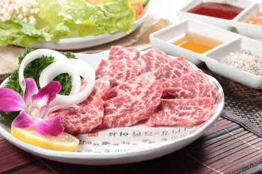 raw beef with spices and vegetables on background, close up