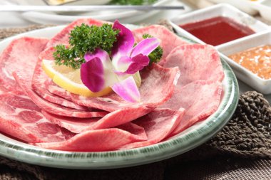 Baharatlı çiğ et ve arka planda maydanoz.