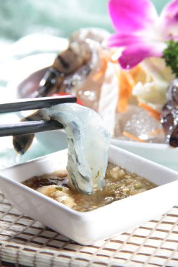 Arkadaki lezzetli karideslerin ve çiçeklerin manzarasını kapat.