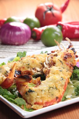 Arka planda salata yaprakları olan lezzetli kızarmış karideslerin yakın görüntüsü