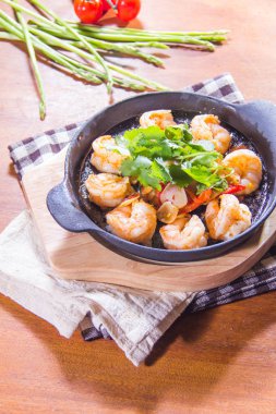 Arka planda baharatlı sebzeli kızarmış karides.