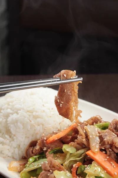 Kızarmış domuz, sebze ve pilav.