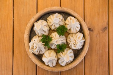 Hıngel ahşap bir masa üzerinde bir tabakta. Geleneksel Gürcü mutfağı. Gürcü halkının mutfağı.