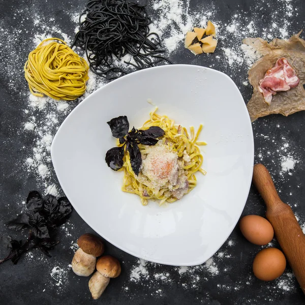 Massa Carbonara. Espaguete com bacon, parsel e queijo parmesão. Massa Carbonara em placa branca com parmesão sobre fundo escuro. Conceito de comida italiana. Vista superior . — Fotografia de Stock