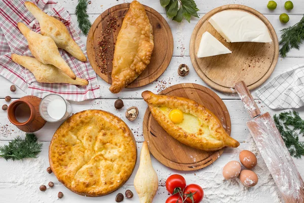 전통적인 그루지야어 아자리야 khachapuri와 Kolkh khachapuri 테이블에. 홈메이드 베이킹입니다. 최고의 볼 수 있습니다. 평면 배치 — 스톡 사진