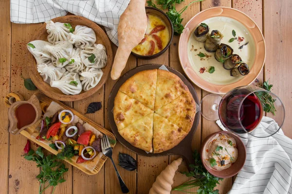 A lot of food on the wooden table. Georgian cuisine. Top view. Flat lay . Khinkali and Georgian dishes — Stock Photo, Image