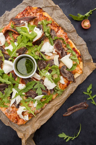 Пицца на тёмном деревянном фоне — стоковое фото