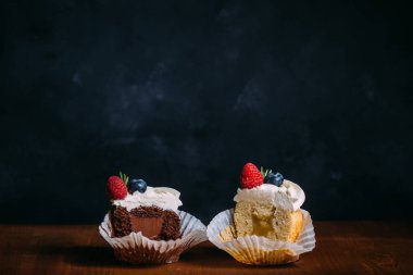 Taze lezzetli kek çilek ile. Seçici odak. Koyu ahşap arka plan. Rustik tarzı, metin için yer. cupcakes kesmek