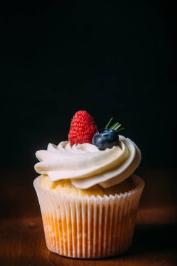 Taze lezzetli vanilyalı kek çilek ile. Seçici odak. Koyu ahşap arka plan. Rustik tarzı, metin için yer