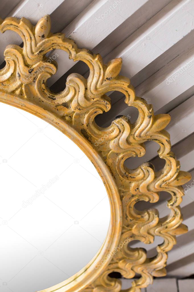 Antique beautiful rustic vintage gold mirror in white interior close up