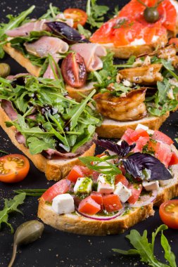 Brushetta şarap için ayarlayın. Küçük sandviç salam, domates, kaşar peyniri, taze fesleğen ile çeşitli