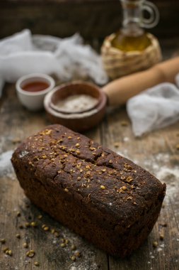 Taze kahverengi gevrek somun ekmek un serpilir ahşap masa yatan görünümünü kapat.