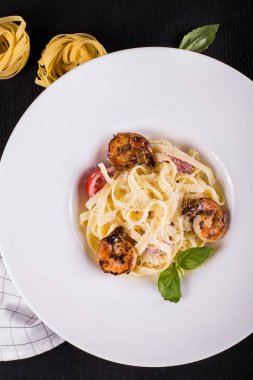 Deniz ürünleri. Kabuklu deniz ürünleri. Makarna, ızgara karides karides ile domates, fesleğen taze otlar ve baharatlar