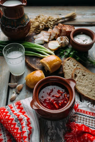 Борщ - свекольный суп в глиняной чаше на деревянном фоне, традиционное блюдо украинской и русской кухни . — стоковое фото