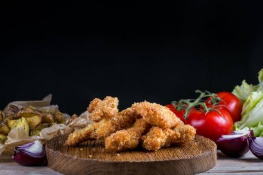 Ahşap zemin üzerine Sebzeli tavuk göğsü nuggets. Çıtır ev yapımı fırında tavuk nuggets soğutma yığını.