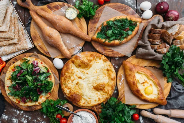 Traditional Georgian adjara khachapuri and Kolkh khachapuri on the table. Homemade baking. Top view. Flat lay — Stock Photo, Image