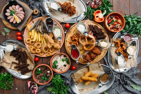 Table à manger avec crevettes, poisson grillé, salade, différentes collations et bière allégée, vue sur le dessus — Photo