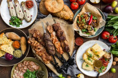 Açık havada yemek kavramı. İştah açıcı mangalda biftek, sosis ve ahşap bir piknik masa üzerinde ızgara sebze.