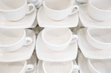 Çok sayıda satır beyaz kahve fincanı, çay kaşığı ve fincan tabağı tablo Tarih temiz. Satırda ayarla boş kupa kahve molası için hazırlamak