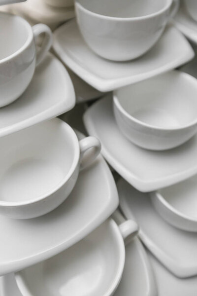 Many rows clean white coffee cup, tea spoon and saucer on table. Empty mug set in row prepare for coffee break