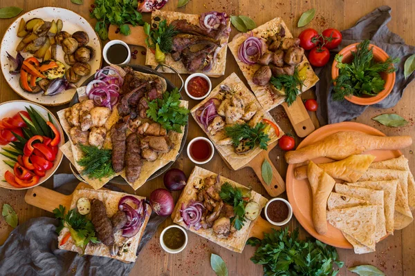 Açık havada yemek kavramı. İştah açıcı mangalda biftek, sosis ve ahşap bir piknik masa üzerinde ızgara sebze. — Stok fotoğraf