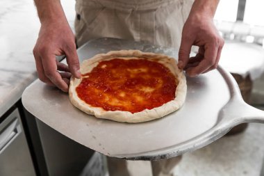 Taze orijinal İtalyan ham pizza, hazırlık, geleneksel tarzda. Elinde Şef baker mutfak at pizza yapma.