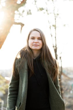 Parktaki genç ve güzel kadın fotoğrafçıya poz veriyor.