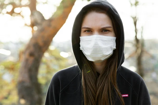 Närbild av kvinna bär skyddande ansiktsmask. Begreppet utbrott av Coronavirus covid-19. Stockbild