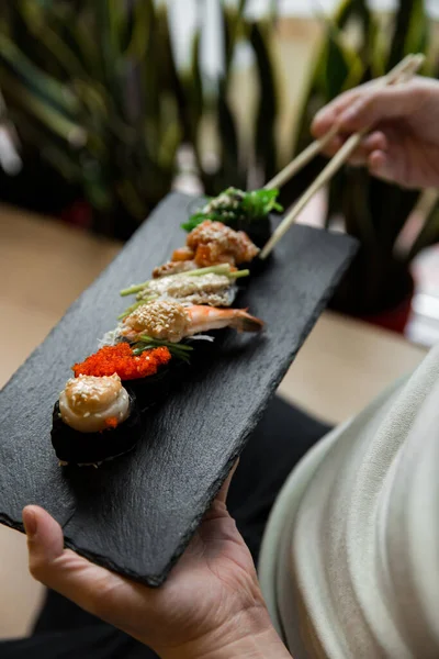 Maki di sushi gunkan fresco assortito con frutti di mare. serie di pistole in mano. Focus selettivo . — Foto Stock