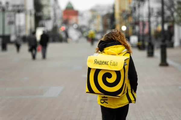 Nizjnij Novgorod, Ryssland - 24 april 2019: Yandex eda Yadex food. Kurirer som levererar mat på en stadsgata. Stockbild