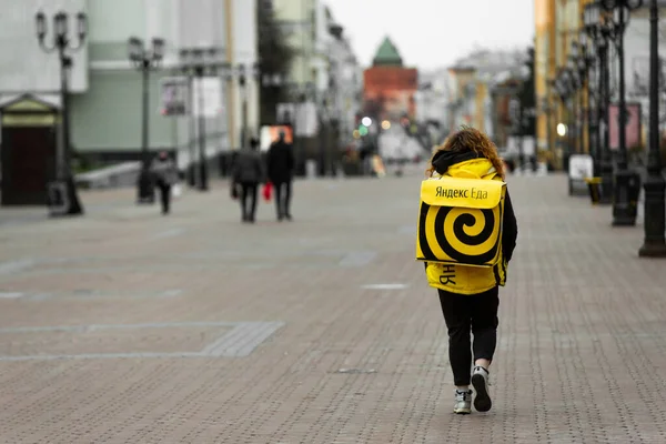 Nizjnij Novgorod, Ryssland - 24 april 2019: Yandex eda Yadex food. Kurirer som levererar mat på en stadsgata. Stockfoto