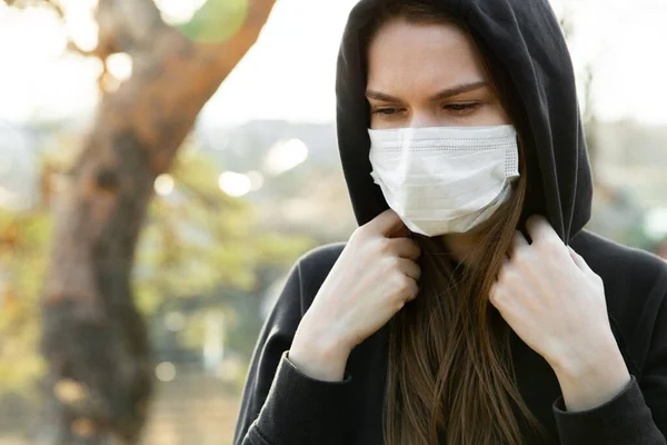 Kvinnan bär ansiktsmask under utbrottet av coronavirus. Skydd mot virusinfektion i avgaserna och industriutsläpp Stockbild