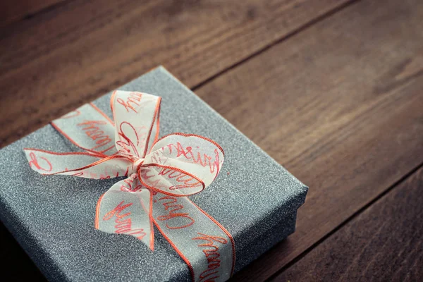 Серебряная подарочная коробка с рождественской лентой — стоковое фото