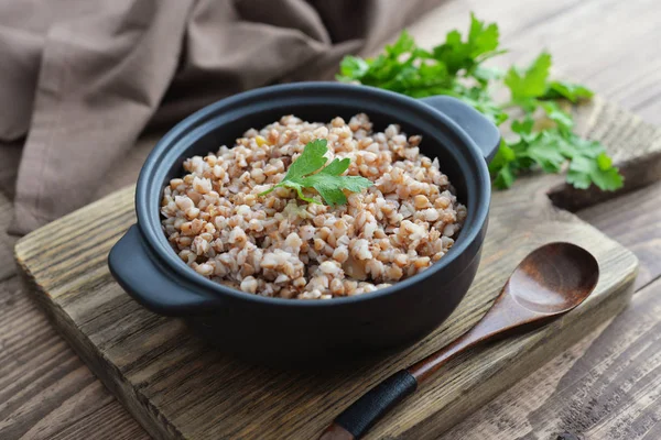 Buckwheat porridge in black casserole — Stock Photo, Image