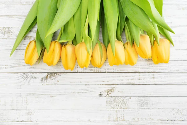 Tulipanes amarillos sobre fondo de madera — Foto de Stock