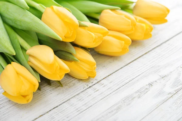 Tulipas amarelas sobre fundo de madeira — Fotografia de Stock