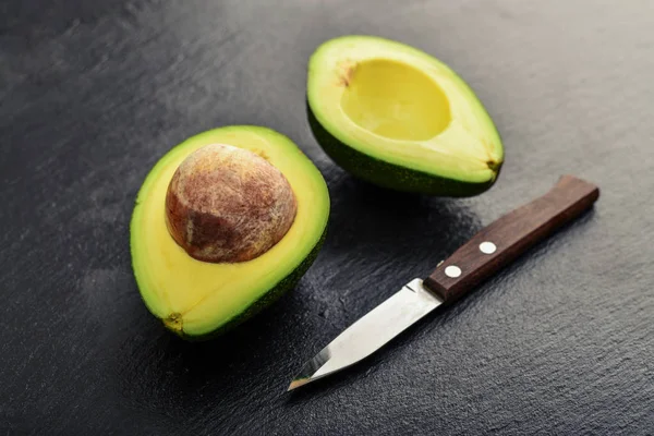 Verse avocado over zwarte leisteen achtergrond — Stockfoto
