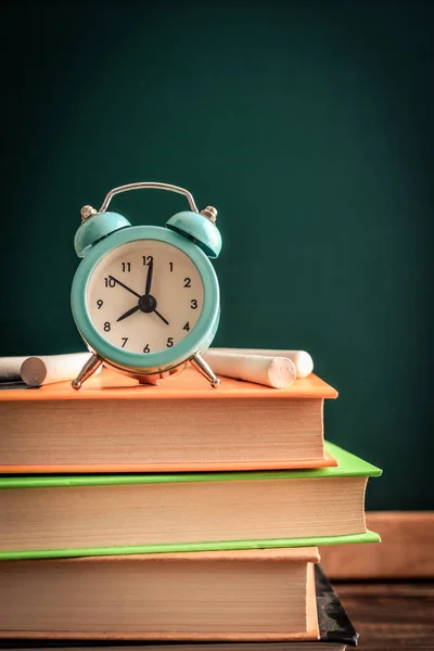 Relógio de alarme na pilha de livros — Fotografia de Stock