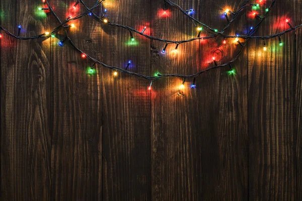 Kerstverlichting op houten achtergrond — Stockfoto