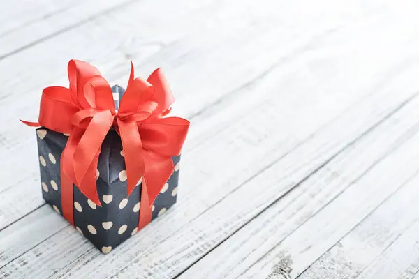 Gepunktete Geschenkbox Mit Rotem Band Auf Weißem Holzhintergrund — Stockfoto