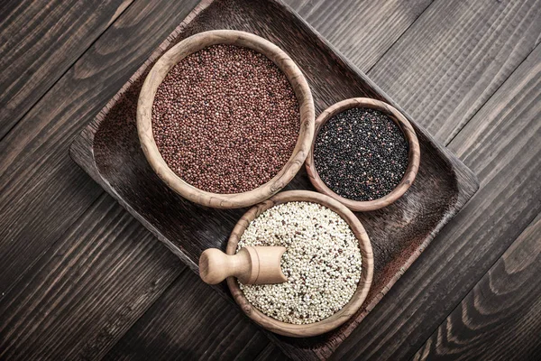Diferentes Tipos Sementes Quinoa Cruas Tigela Madeira Fundo Madeira Vista — Fotografia de Stock