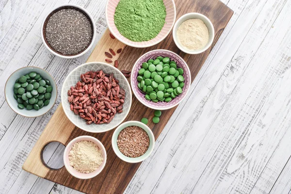 Verschillende Super Foods Kommen Witte Houten Achtergrond Bovenaanzicht — Stockfoto