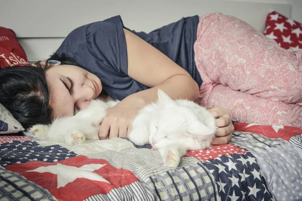Bílá kočka a dívka spí spolu — Stock fotografie