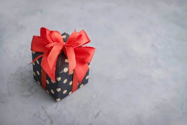 Kırmızı kurdeleli benekli hediye kutusu — Stok fotoğraf