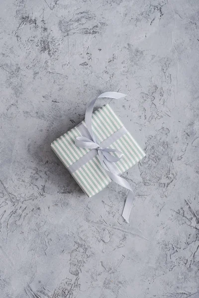 Una caja de regalo a rayas con cinta gris —  Fotos de Stock