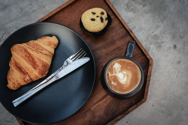 Чашка кофе с латте сверху и круассан с маслом — стоковое фото